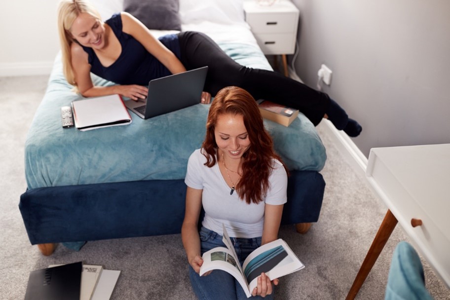 Two female students studying together in a dorm room